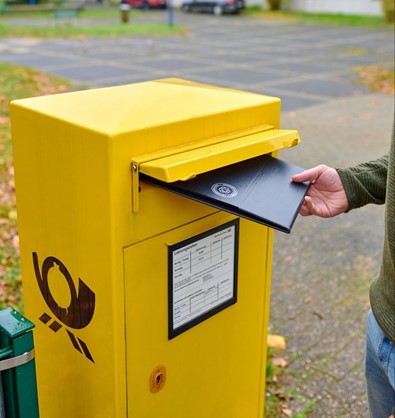 Eine Mehrwegverpackung wird in einen Briefkasten geworfen